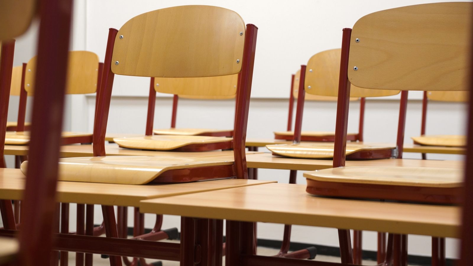Salle de classe vide avec chaises sur les tables dans une école