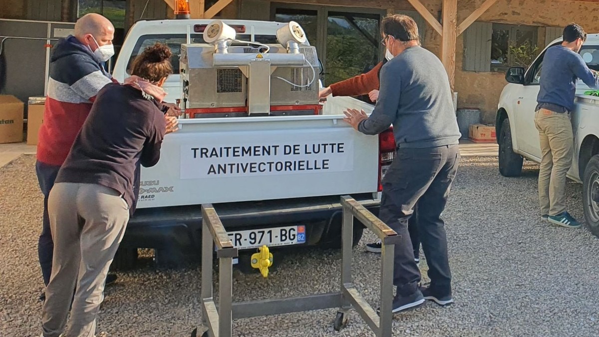 Agents de démoustication chargeant une unité de traitement de lutte antivectorielle sur un véhicule d'intervention