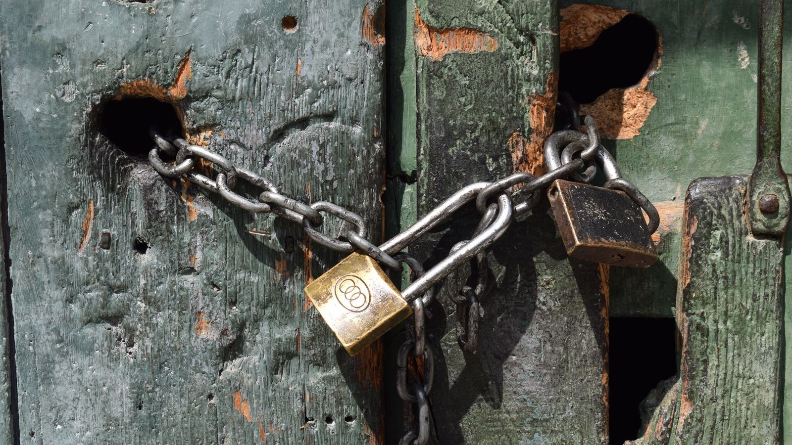 Porte ancienne verrouillée par une chaîne et des cadenas