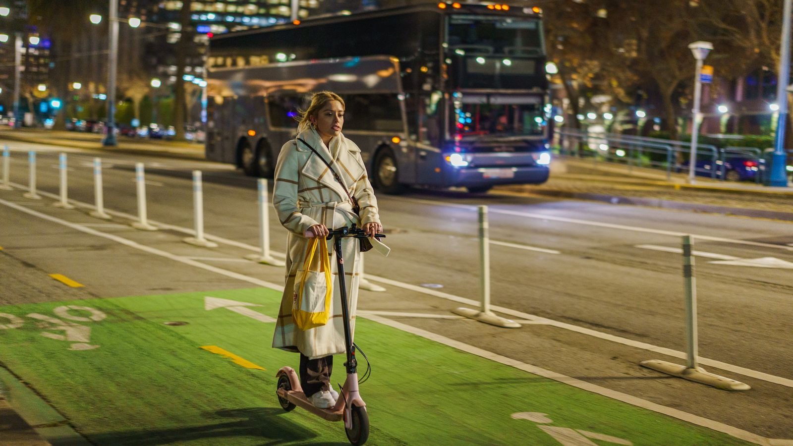 Un usager circule à trottinette électrique sur une piste cyclable en ville