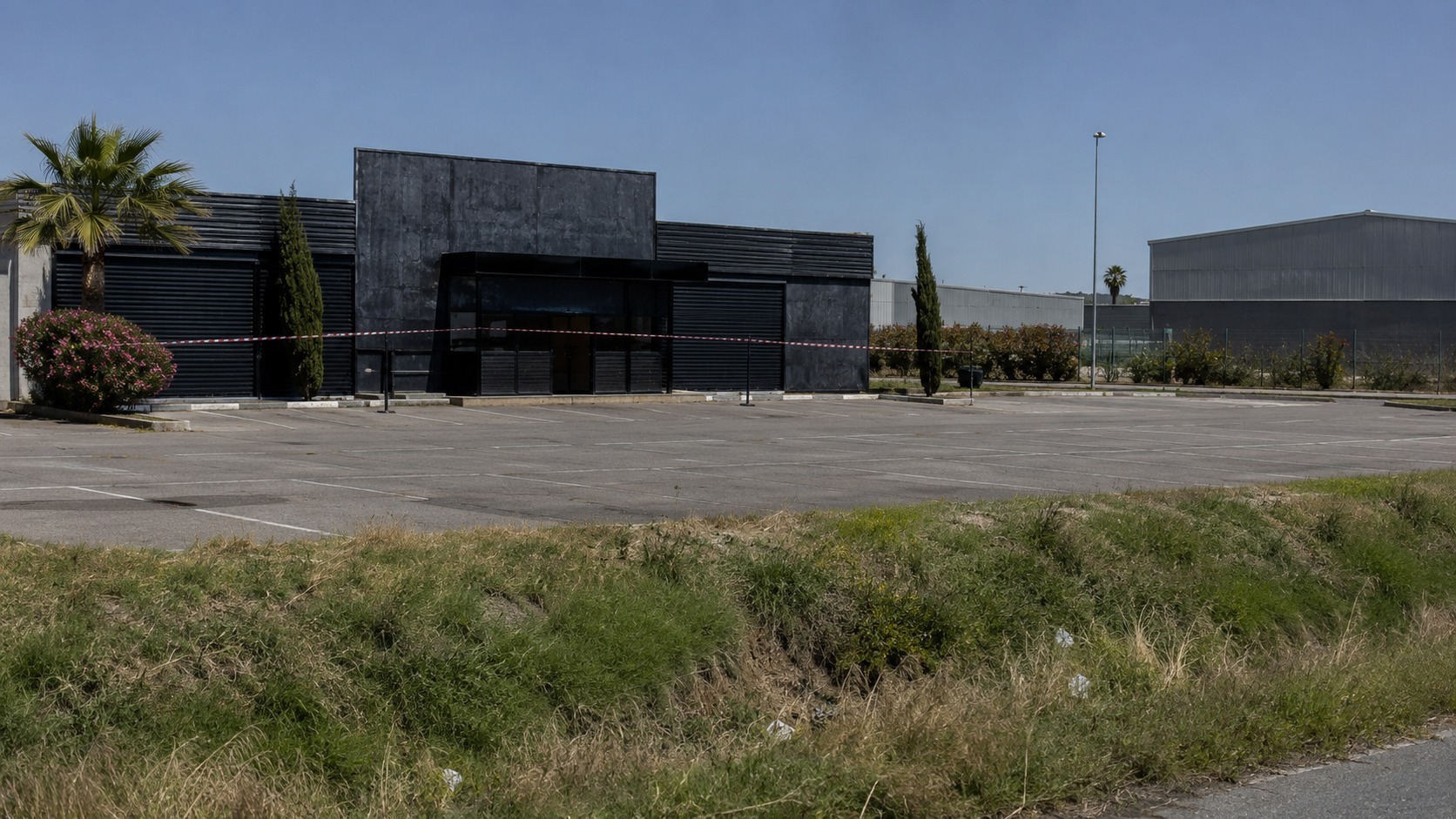 Discothèque fermée et parking désert dans une zone d'activité au sud de Montpellier