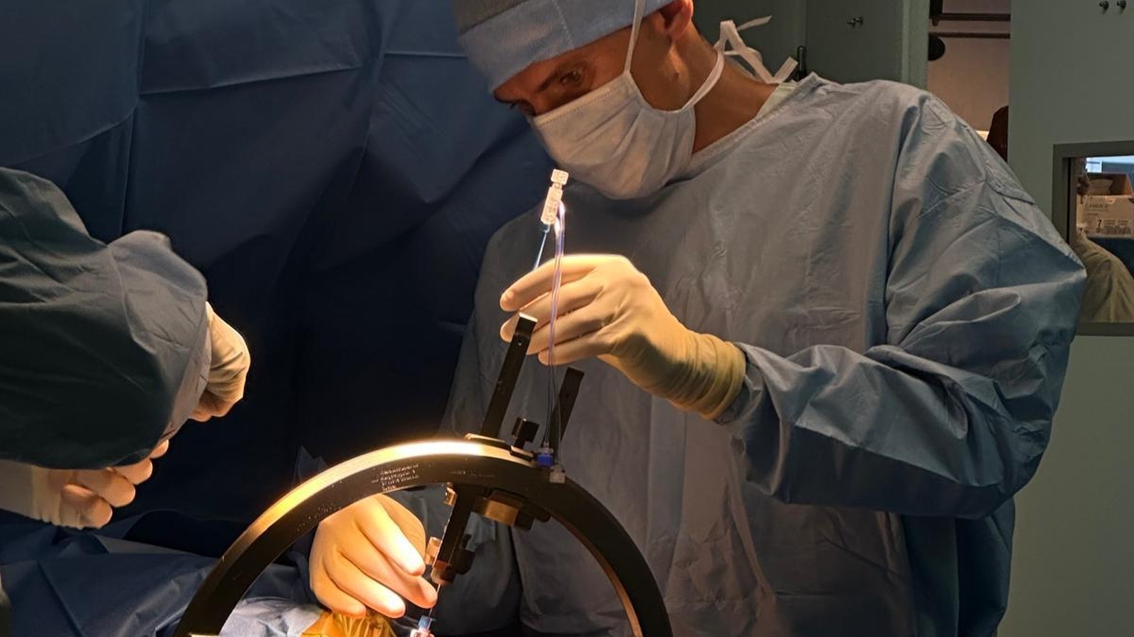Un neurochirurgien introduit une sonde laser dans un cadre stéréotaxique au bloc opératoire du CHU de Montpellier