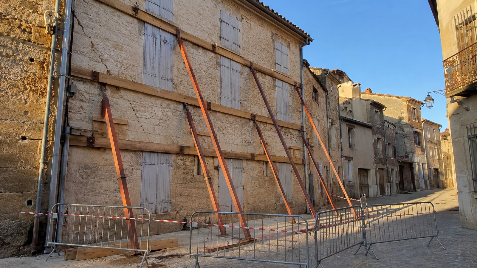 Façade d'un immeuble ancien étayée et rue barrée par des barrières de chantier dans le centre historique de Montpellier