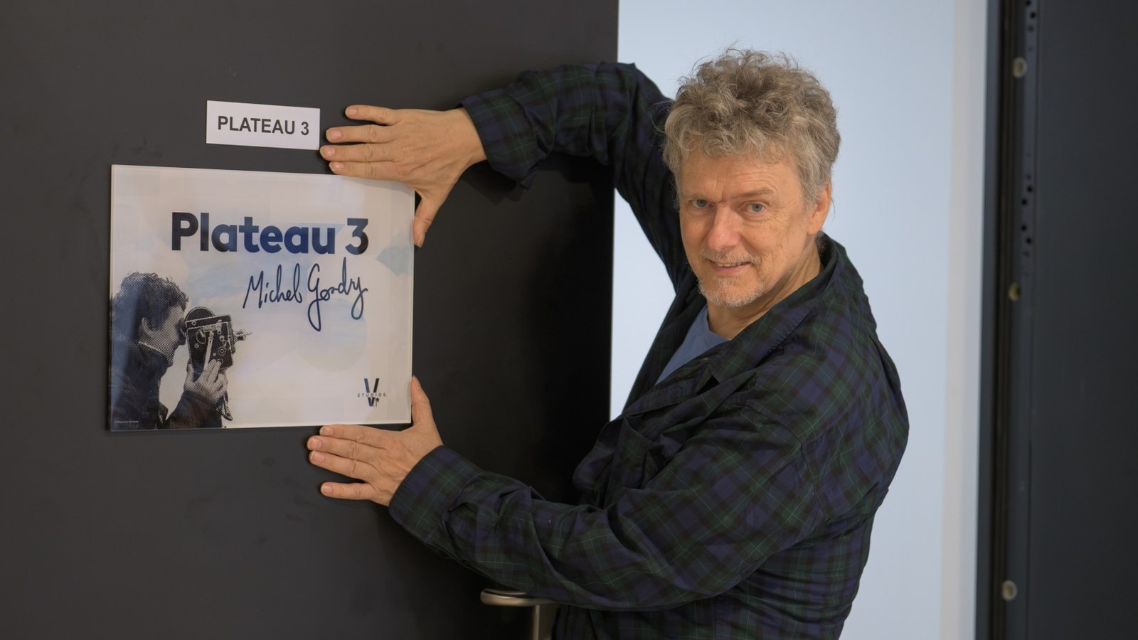 Michel Gondry devant la plaque du plateau 3 à son nom, aux studios V de Vendargues