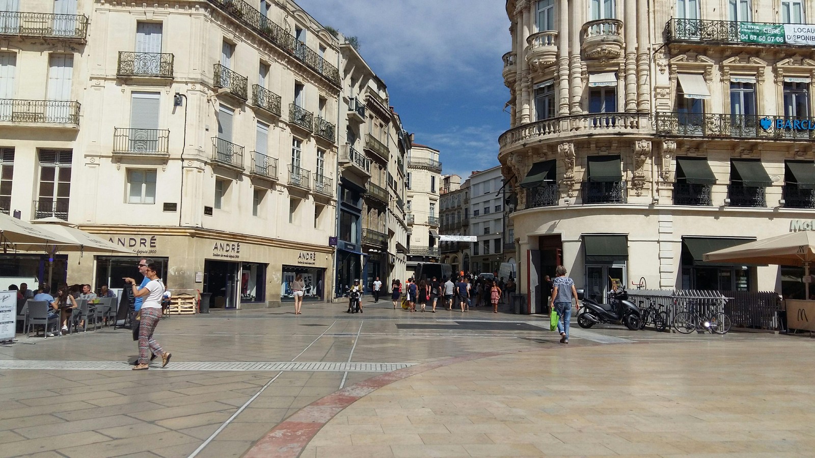Passants et terrasses au début de la rue de la Loge, dans le centre-ville de Montpellier, un jour d'été