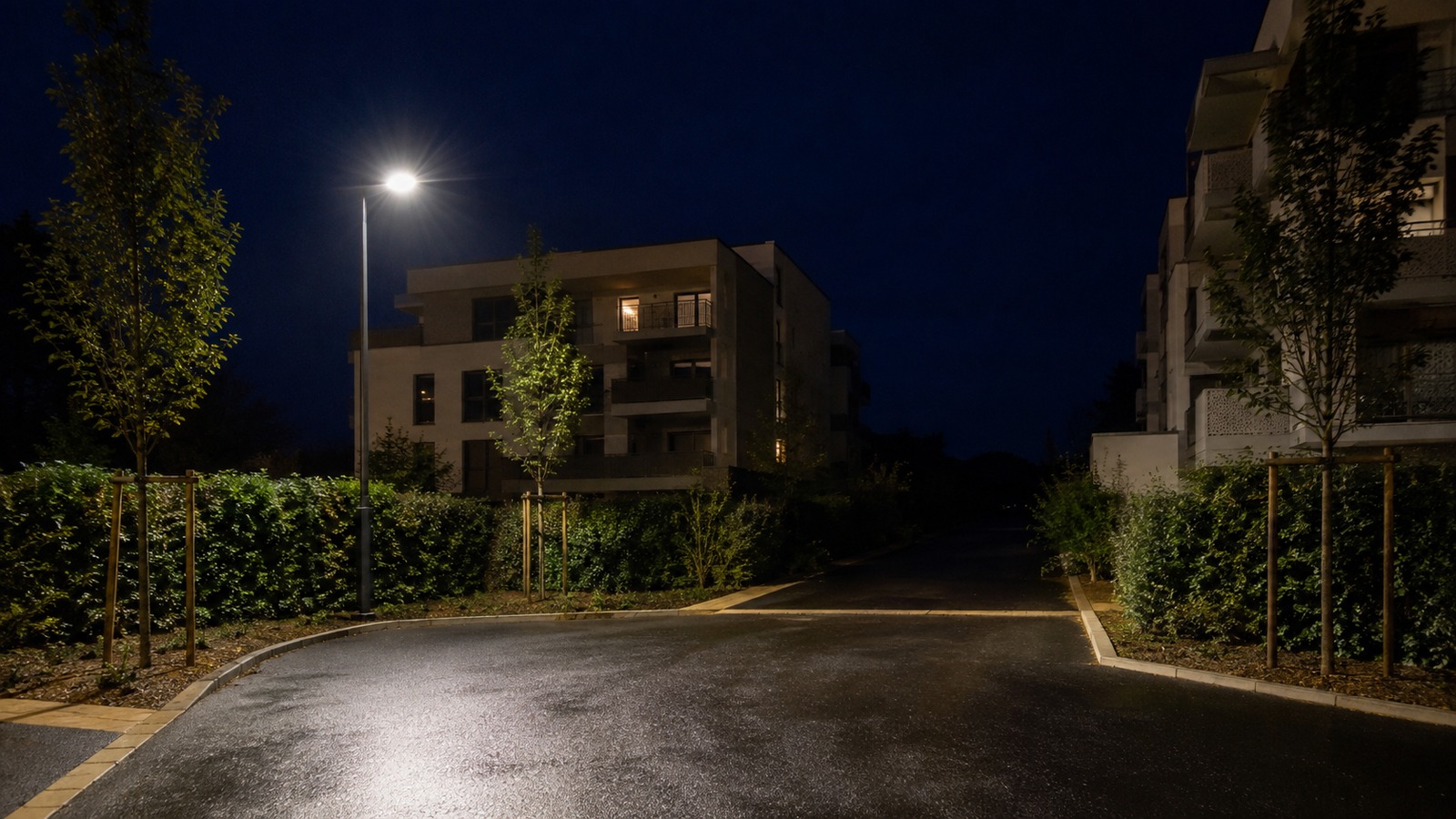 Rue résidentielle éclairée par un lampadaire la nuit dans un quartier neuf de Montpellier