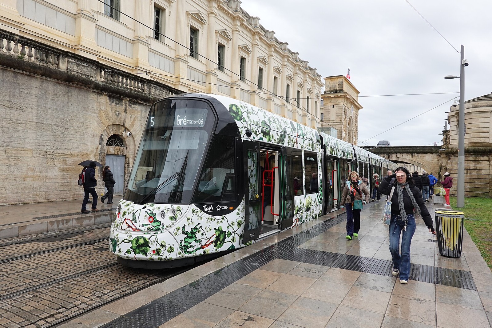 Rame de la ligne 5 du tramway de Montpellier à quai, voyageurs sur le trottoir