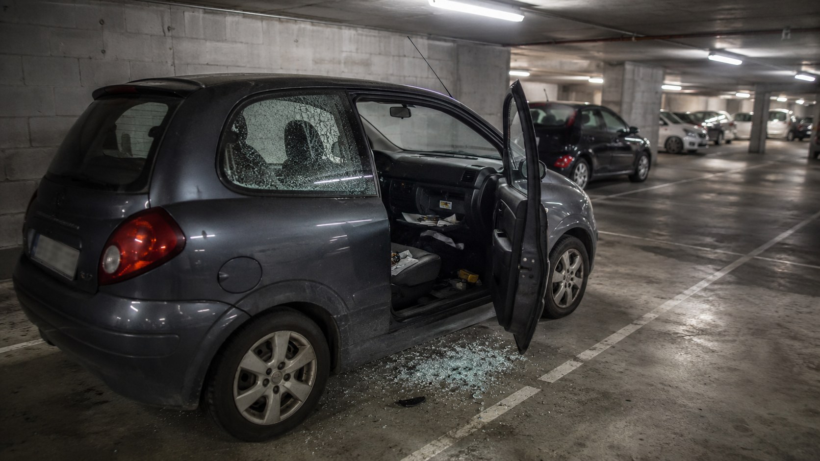 Voiture a la vitre brisee dans un parking souterrain de residence a Montpellier