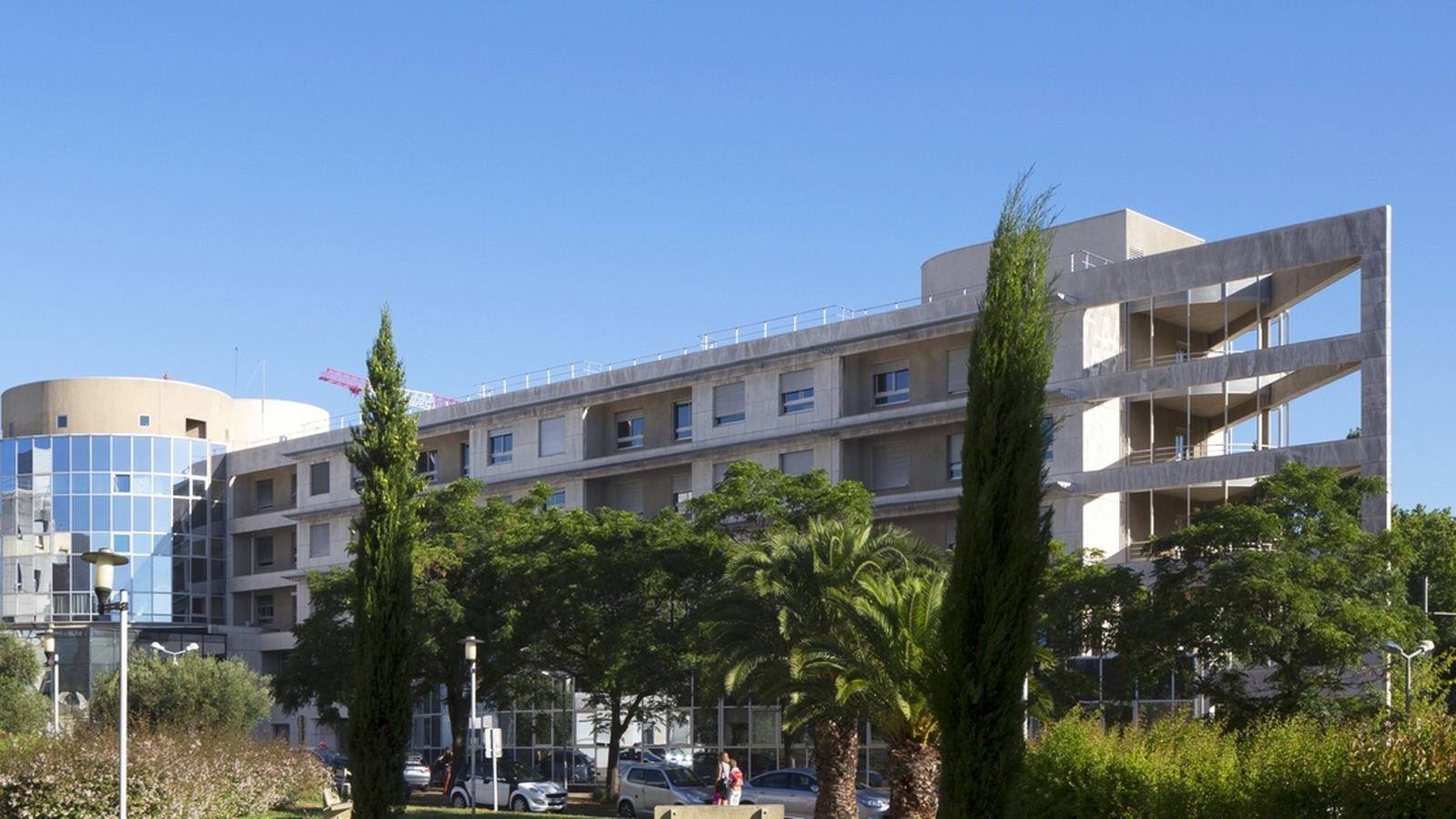 Façade de l'hôpital Arnaud-de-Villeneuve du CHU de Montpellier, une grue de chantier en arrière-plan