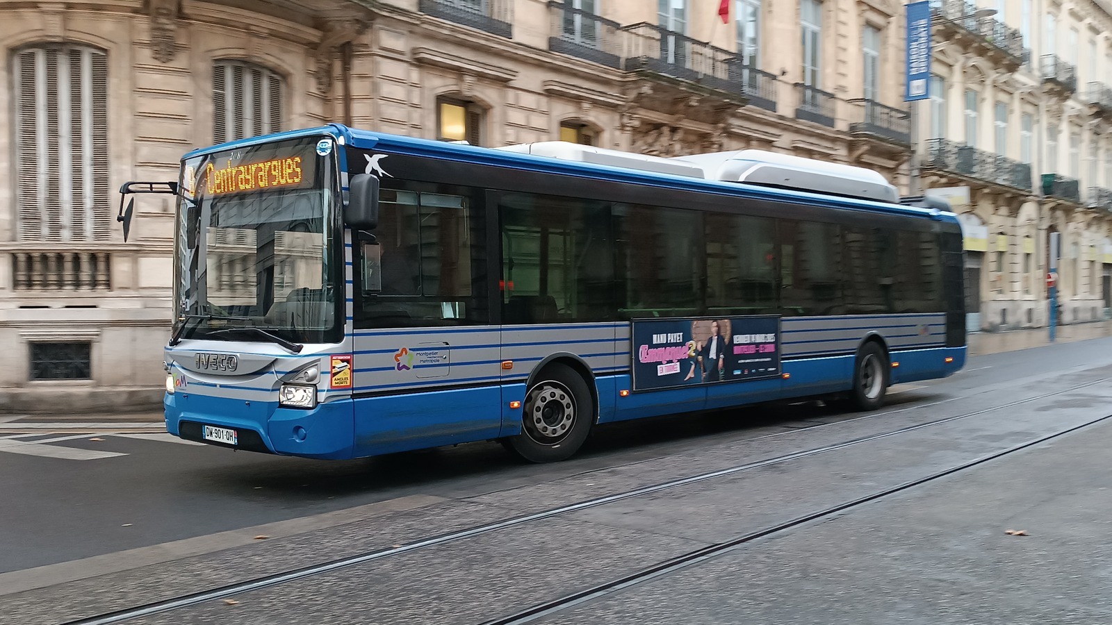 Bus du réseau TaM circulant à Montpellier avec un encart publicitaire sur le flanc
