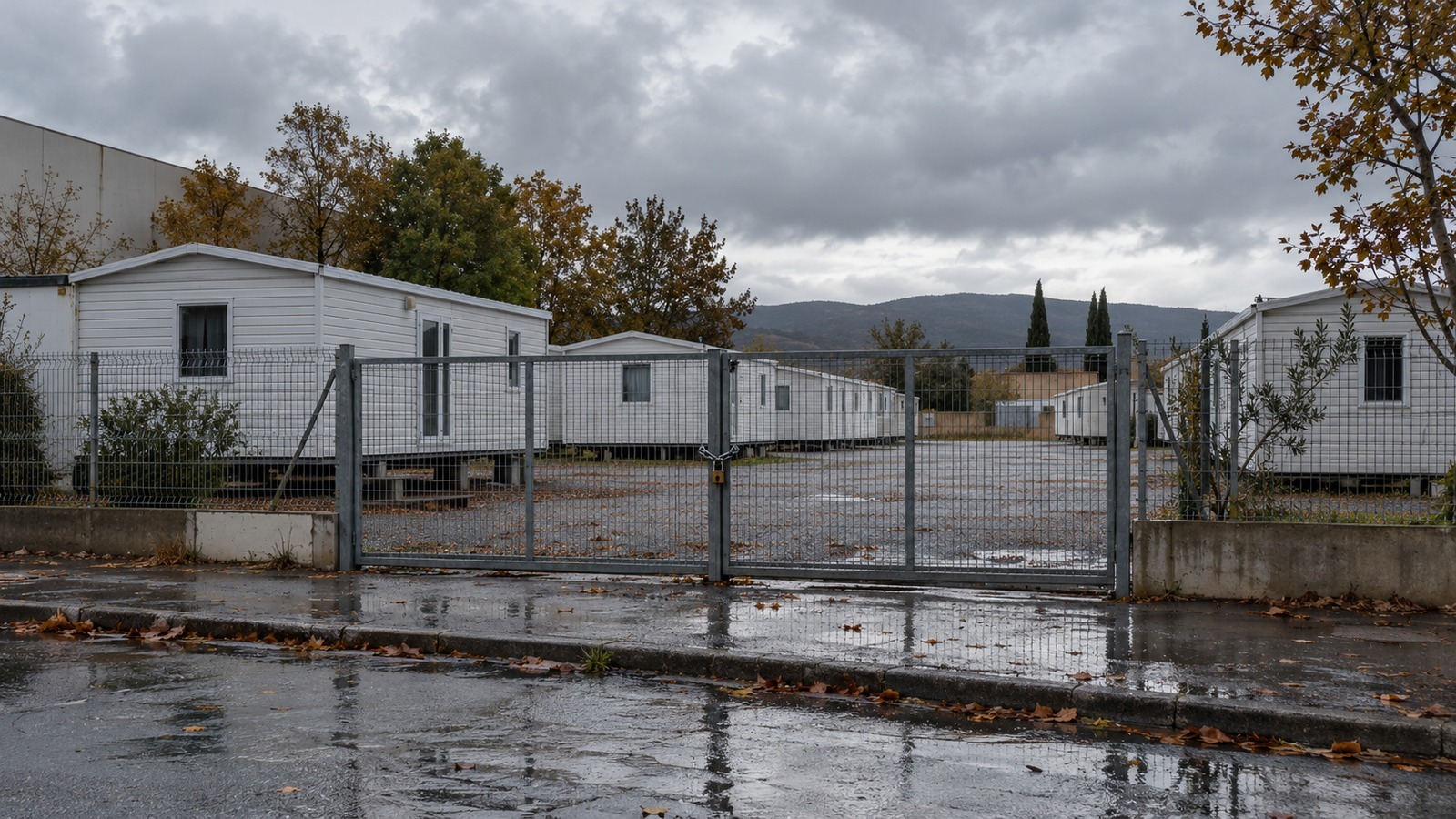 Mobil-homes d'un centre d'hébergement d'urgence de nuit fermé derrière un portail cadenassé (illustration)